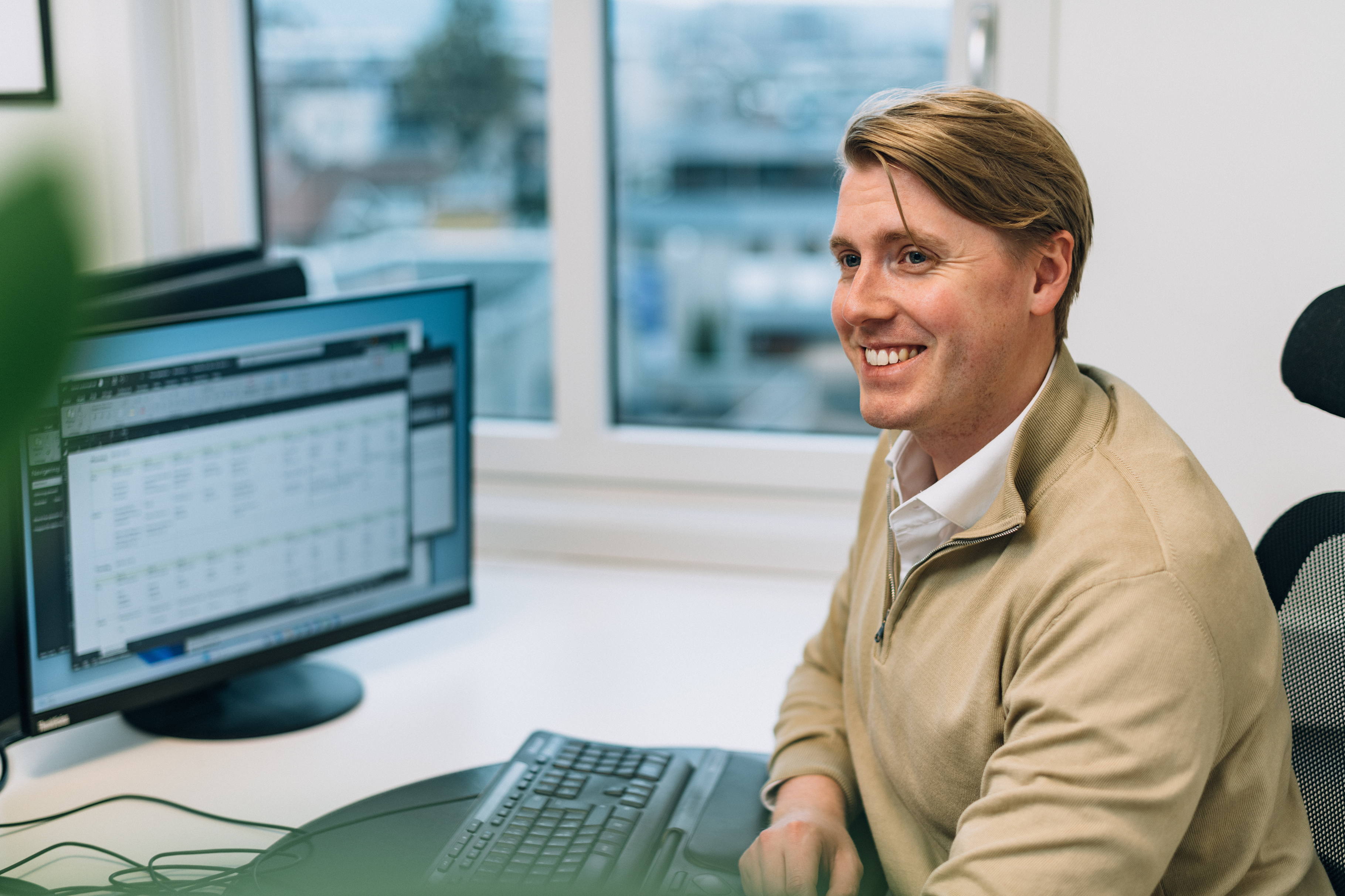 Ansatt Johan foran pc skjermer med analyse av kundes data