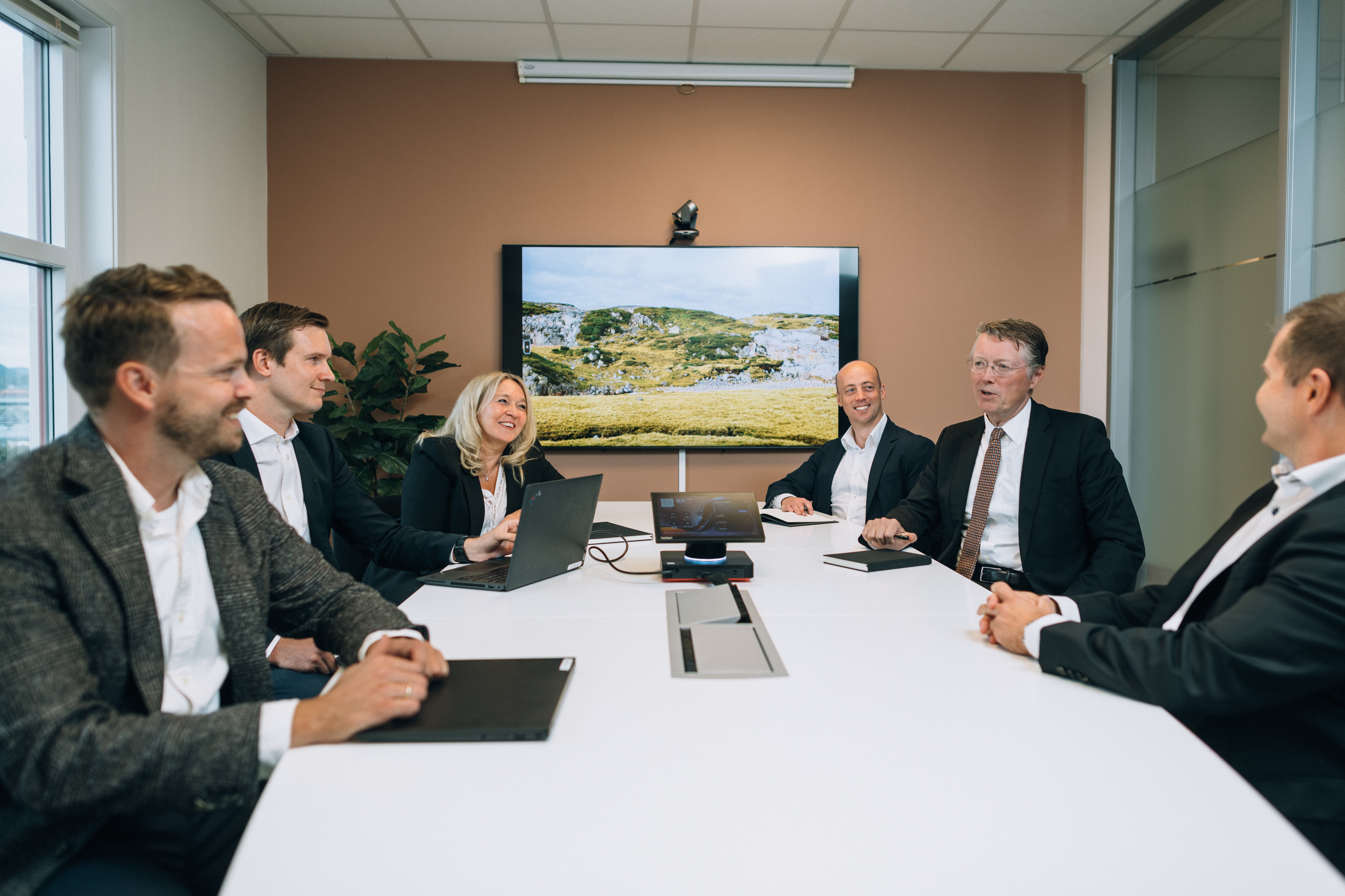 Ledergruppen samlet rundt avlangt hvitt bord på møterom