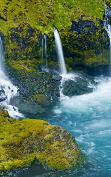 Several small waterfalls that end in a large blue pool